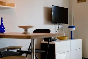 a room with a table and a tv on a cabinet at Studio agréable 300m Côte Sauvage in Le Pouliguen +30 photos