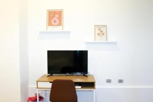 a television sitting on a desk with a chair at di fronte al museo in Gela