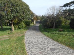 a cobblestone path in a park with trees at Deliziosa Villa Panoramica in Campagnano di Roma