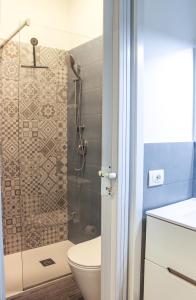 a bathroom with a toilet and a glass shower at di fronte al museo in Gela
