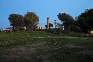 a field with a tower on top of a hill at di fronte al museo in Gela
