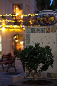 a sign with a tree in front of a building at di fronte al museo in Gela +7 photos