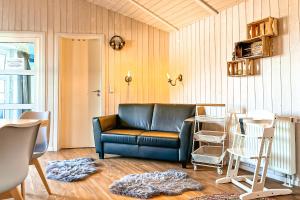 a living room with a blue couch and chairs at Strandblick - Dorf 1 Ferienhaus 16 in Priwall