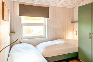 a small bedroom with a bed and a window at Strandblick - Dorf 1 Ferienhaus 16 in Priwall +66 photos