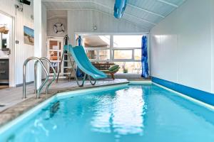 a swimming pool with blue chairs in a house at Strandblick - Dorf 1 Ferienhaus 16 in Priwall