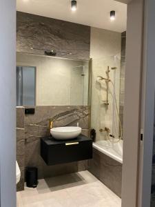 a bathroom with a sink and a toilet and a tub at Apartament ELEGANCE in Zamość