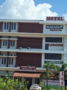 a hotel with a sign on the side of it at Hotel Abhinav Boarding And Lodging in Udupi
