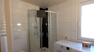 a bathroom with a shower and a toilet and a sink at Chalet 1021 in Nideggen