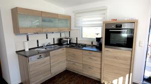 a small kitchen with wooden cabinets and a sink at Chalet 1021 in Nideggen