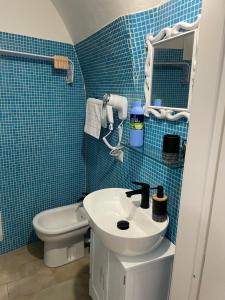 サッサリにあるLa casa di Pi Taの青いタイル張りのバスルーム(洗面台、トイレ付)