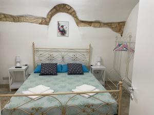 a bedroom with a bed with blue sheets and pillows at La casa di Pi Ta in Sassari