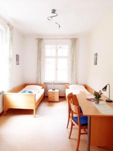 une chambre avec un lit, un bureau et une table dans l'établissement Die Malche Gäste und Tagungshaus 26, à Malche 18 autres photos