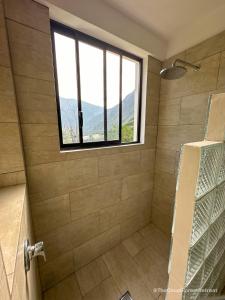 a bathroom with a shower with a window at The Cloud Forest Retreat in Pelagallo