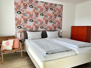 a bedroom with a bed with a floral wallpaper at Dünenrose Seegras Nr 41 in Norderney +13 photos
