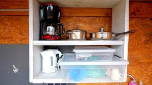 a kitchen shelf with pots and pans on it at Wohnfass Terrasse 1011 in Nideggen