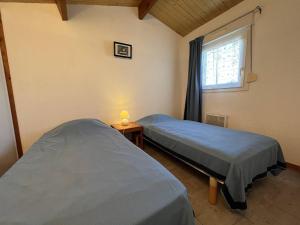 zwei Betten in einem Zimmer mit Fenster in der Unterkunft Mais 4 pièces Oléron 6 couchages - SAINT-DENIS D'OLERON SDO000-013 in Saint-Denis-dʼOléron