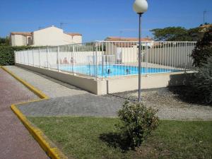 ein weißer Zaun neben einem Pool in der Unterkunft Mais 4 pièces Oléron 6 couchages - SAINT-DENIS D'OLERON SDO000-013 in Saint-Denis-dʼOléron