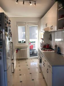 a kitchen with a tile floor and a large window at Recently renovated room with Danube view in Novi Sad