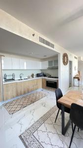 阿布扎比Apartment in Abu Dhabi for rent的带木桌的厨房和带水槽的厨房