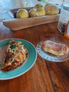 une table avec deux assiettes de pizza et un plateau de pommes de terre dans l'établissement Hostel Lençóis em Santo Amaro MA, à Santo Amaro 37 autres photos