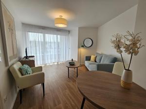 a living room with a couch and a table at Zenao Appart'hôtels Saint-Maur-des-Fossés in Saint-Maur-des-Fossés +2 photos