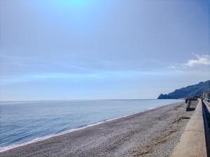 ein Strand mit einer Bank und dem Meer in der Unterkunft CasaBlanc in Santa Teresa di Riva + 23 Fotos