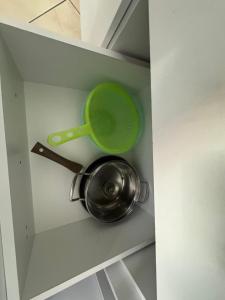 a pot and a green strainer in a drawer at Comfort Apartments Promenade in Sarandë