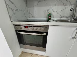 a kitchen with a stove top oven next to a sink at Comfort Apartments Promenade in Sarandë