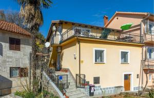 a yellow house with a balcony on top of it at Beautiful Apartment In Opric With Wifi in Opric