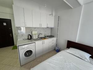 a kitchen with a washing machine next to a bed at Comfort Apartments Promenade in Sarandë