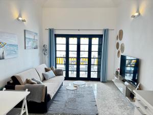 a living room with a couch and a tv at Sotavento 28 in Los Cristianos