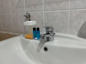 a bathroom sink with a faucet and two bottles on it at Comfort Apartments Promenade in Sarandë