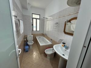 a bathroom with a toilet and a sink and a tub at Comfort Apartments Promenade in Sarandë
