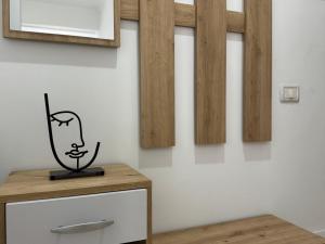 a room with a table with a picture on the wall at Comfort Apartments Promenade in Sarandë