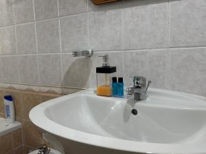 a white sink in a bathroom with aaucet at Comfort Apartments Promenade in Sarandë