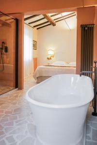 a white bath tub in a room with a bed at L'edicola di Ripalvella in San Venanzo