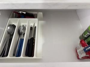 a white tray with utensils in a drawer at Comfort Apartments Promenade in Sarandë