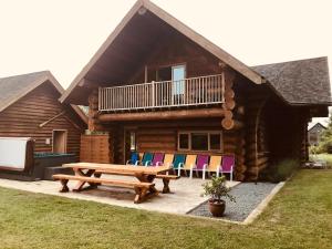 a log cabin with a picnic table and chairs at Fir Lodge in King's Lynn