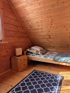 una camera da letto con un letto in una cabina di legno di Domek letniskowy OAZA a Ryn