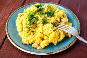 a plate of scrambled eggs with a fork on a table at SIMA - RELAX, Žilina in Žilina +10 photos