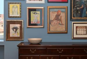 a wall with pictures of women and a dresser at MILIN DOM Premium Apartments in Split