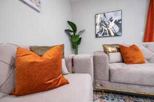 Designer Decorated - 3 Bedroom NEAR DISNEY في كيسيمي: غرفة معيشة مع أريكة مع وسادة برتقال