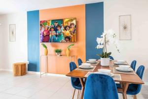 Designer Decorated - 3 Bedroom NEAR DISNEY في كيسيمي: غرفة طعام مع طاولة وكراسي زرقاء +24 صورة