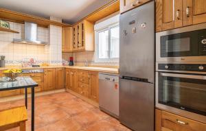 Una cocina con gabinetes de madera y electrodomésticos de acero inoxidable. en Cozy Apartment In Carboneras, en Carboneras