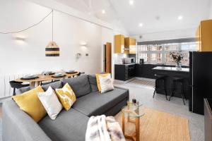 a living room with a gray couch and a kitchen at The Palm- City Centre 2 Bed, Sleeps 7, Netflix in Leicester