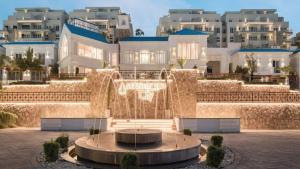 a large building with a fountain in front of it at The Park villa in Madinaty