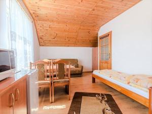 a living room with a bed and a tv at Pokoje Mariola in Karwia