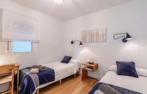 a bedroom with two beds and a desk and a window at Cozy Apartment In Benalmadena With Wifi in Benalmádena +14 photos