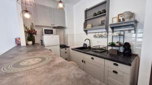 a kitchen with white cabinets and a counter top at Jad Studio Mamaia Nord in Mamaia Nord +13 photos