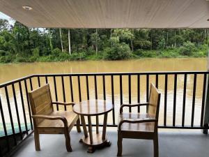 two chairs and a table on a balcony with a view of a river at Floor river view in Cat Tien